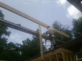 Carpenter setting a ridge beam over a new addition frame — Ice Dam Removal by Roofing Brothers in Villisca