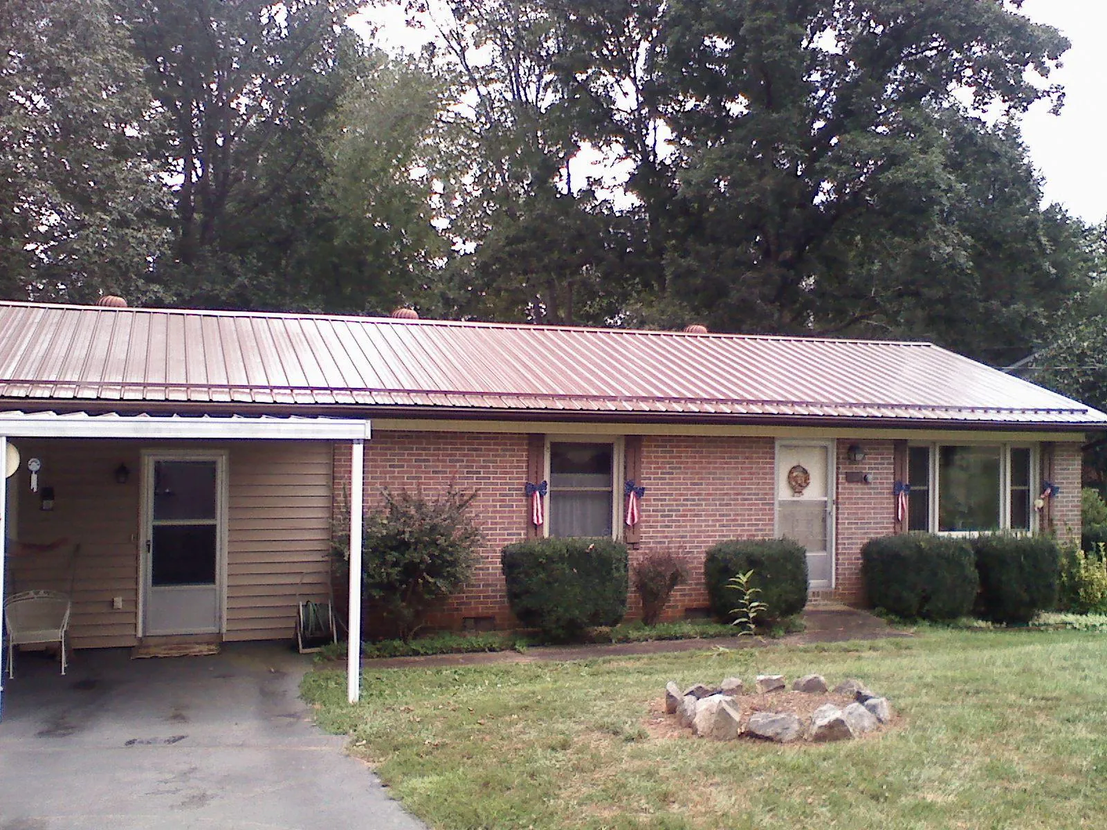 Bronze metal roof and carport on a brick ranch home — Roof Repair work by our crew in Villisca